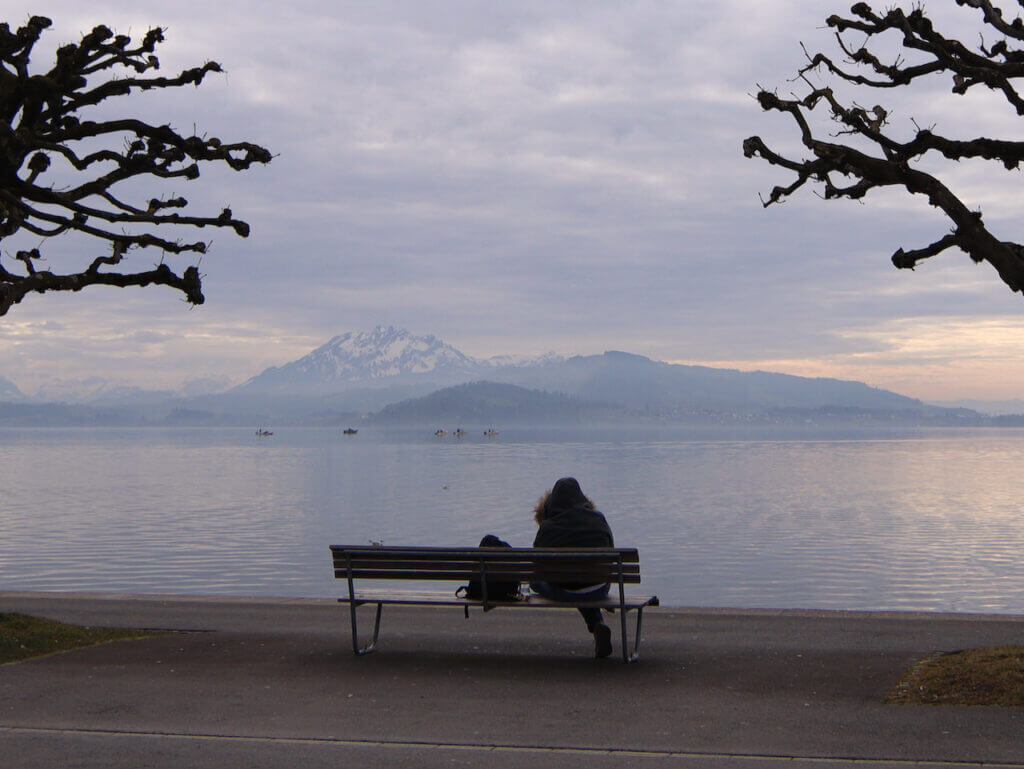 ツーク湖畔の景色とベンチに座っている人
