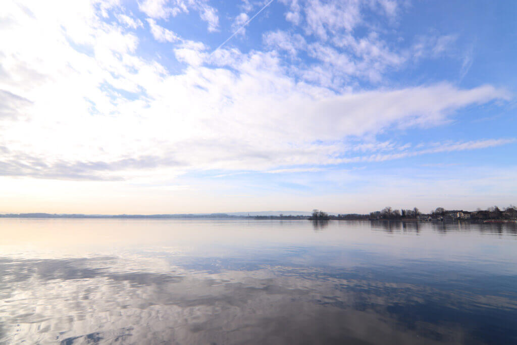 朝の光が静かに広がるツーク湖。水面が空の色を映して、まるで鏡のよう。