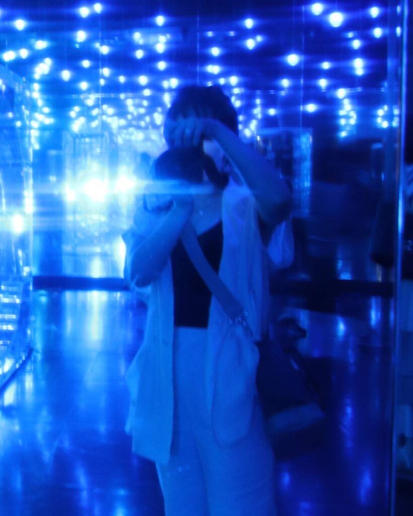 青い光の中で一眼レフを構えている人