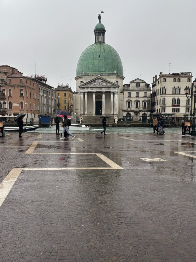 大雨のヴェネチア初日。傘を差す人々とサンタ・ルチア駅前の石畳の風景