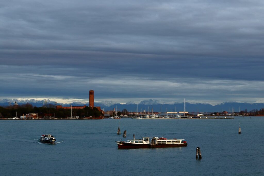 リド島のホテルから望む朝の絶景。行き交うヴァポレットと遠くに広がる雪山
